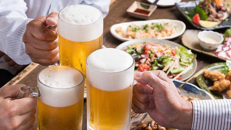 飲み会にてビールで乾杯する画像